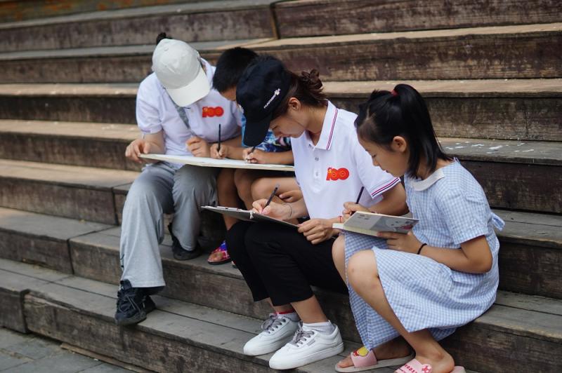 5-大学生志愿者与侗族孩子们一起认真绘画.jpg