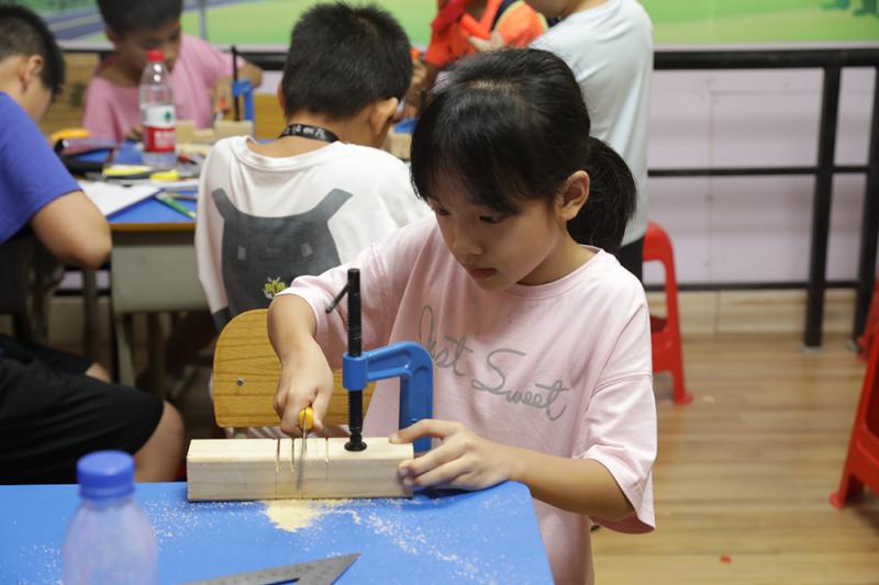 小学员学习手工制作鲁班锁部件.jpg