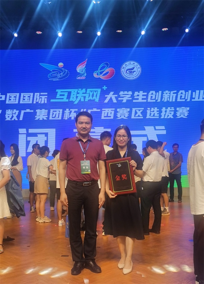 图一 学校领队谭冠晖副校长和我院项目指导老师林英副院长领金奖合影.jpg